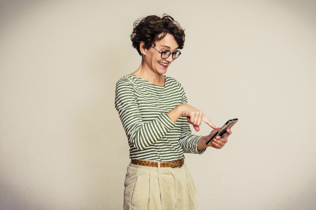 Frau tippt mit dem Zeigefinger auf dem Handy