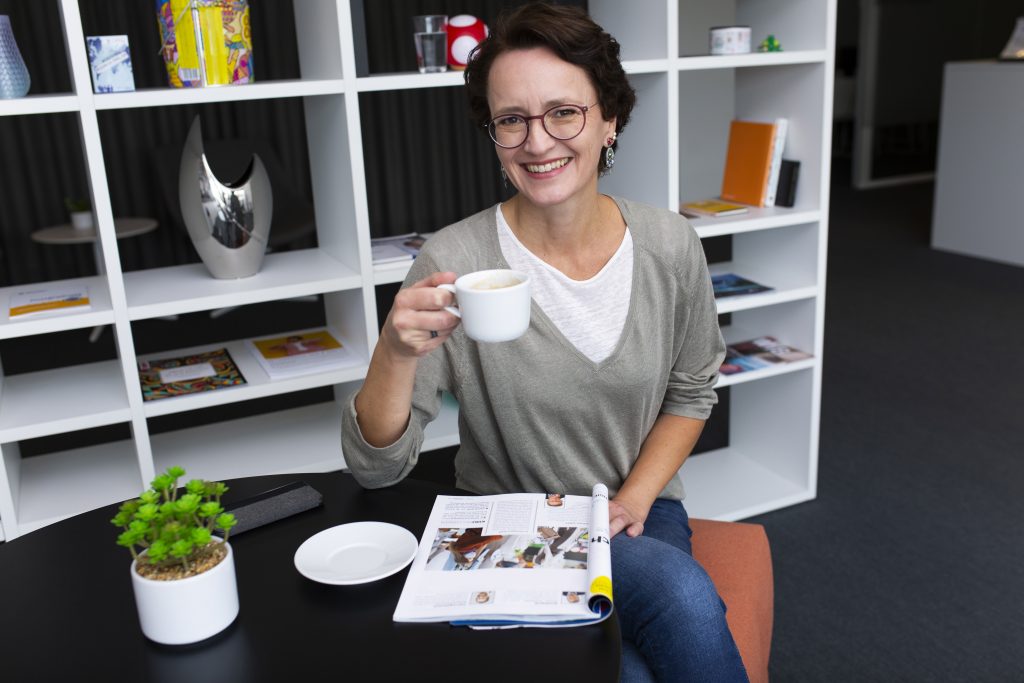 Warum Selbständige einen Blog brauchen: Eva Dragosits mit einer Tasse Kaffee in einem Co-Working Space