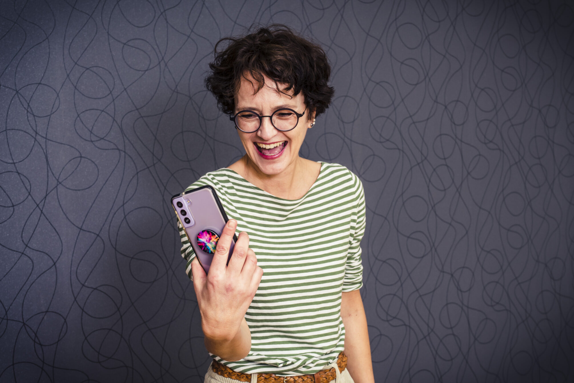 Warum Bloggen: Frau blickt freudestrahlend auf ihr Handy