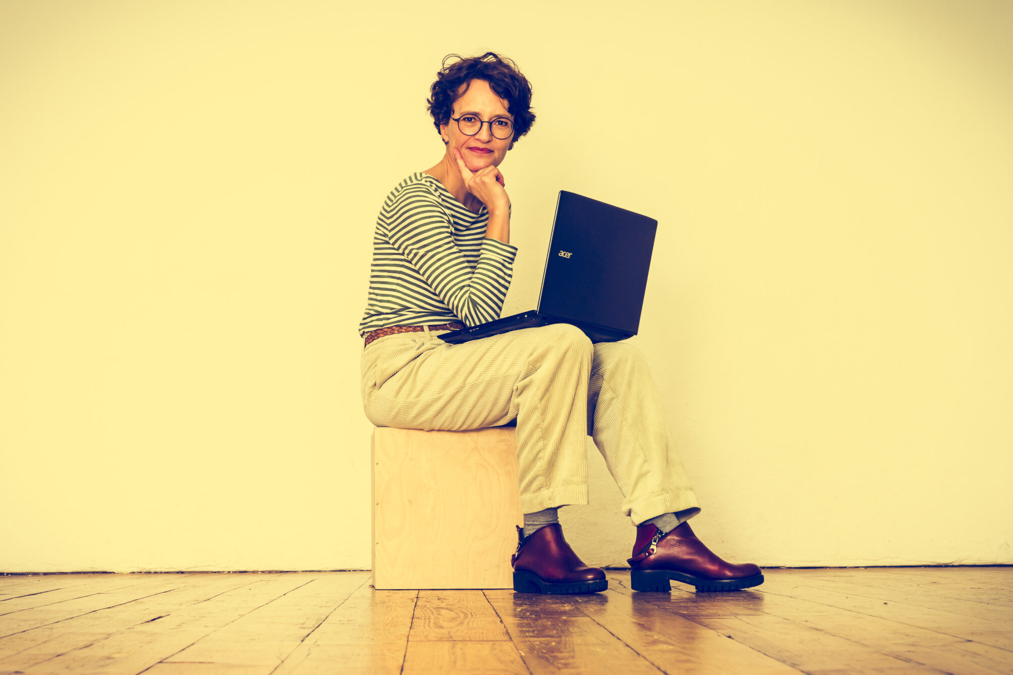 Frau mit Laptop schaut entspannt in die Kamera