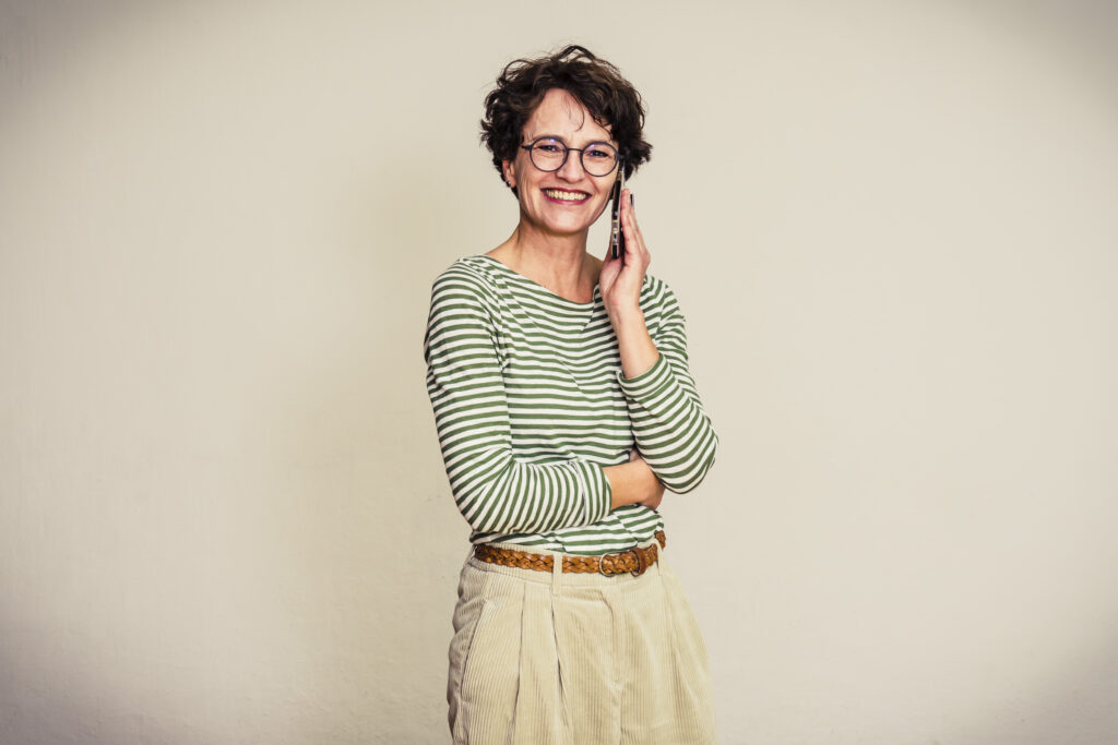 Frau in gestreiftem Shirt telefoniert mit dem Handy