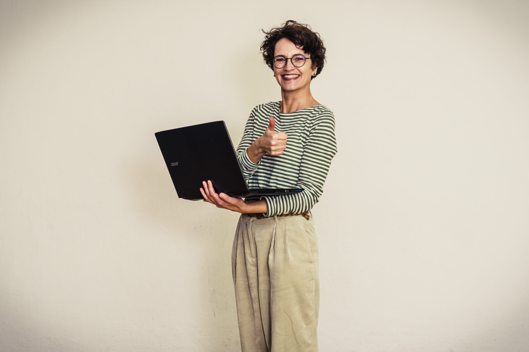 Blog entry Aufbau: Frau mit Laptop und erhobenem Daumen, gutgelaunt