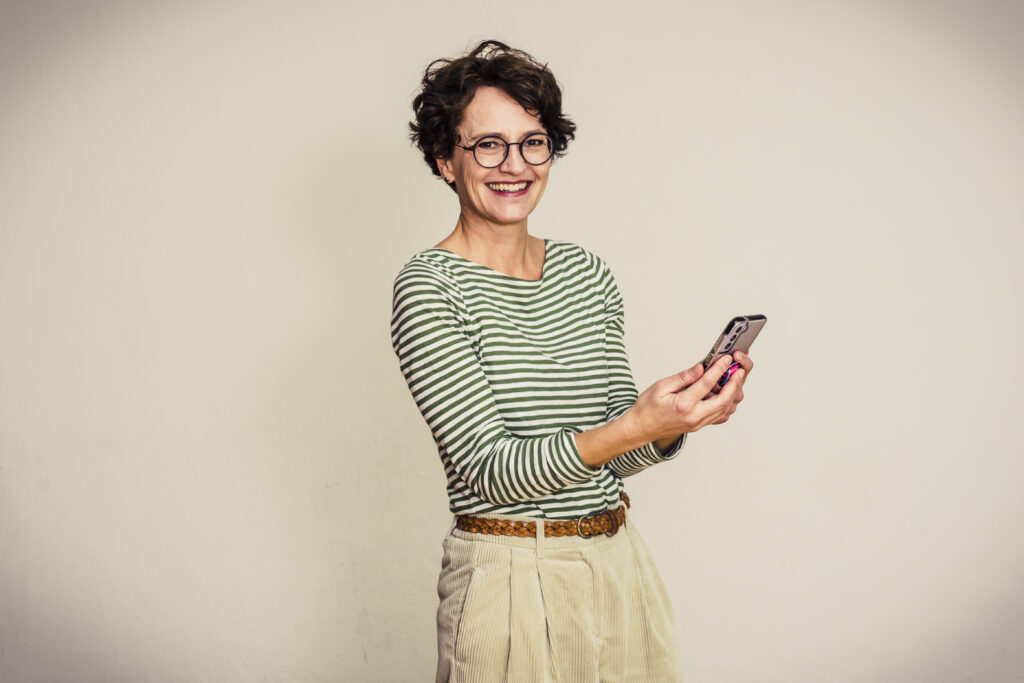 Perfekter Blog Post, Aufbau: Frau sieht happy aus, hat Handy in der Hand