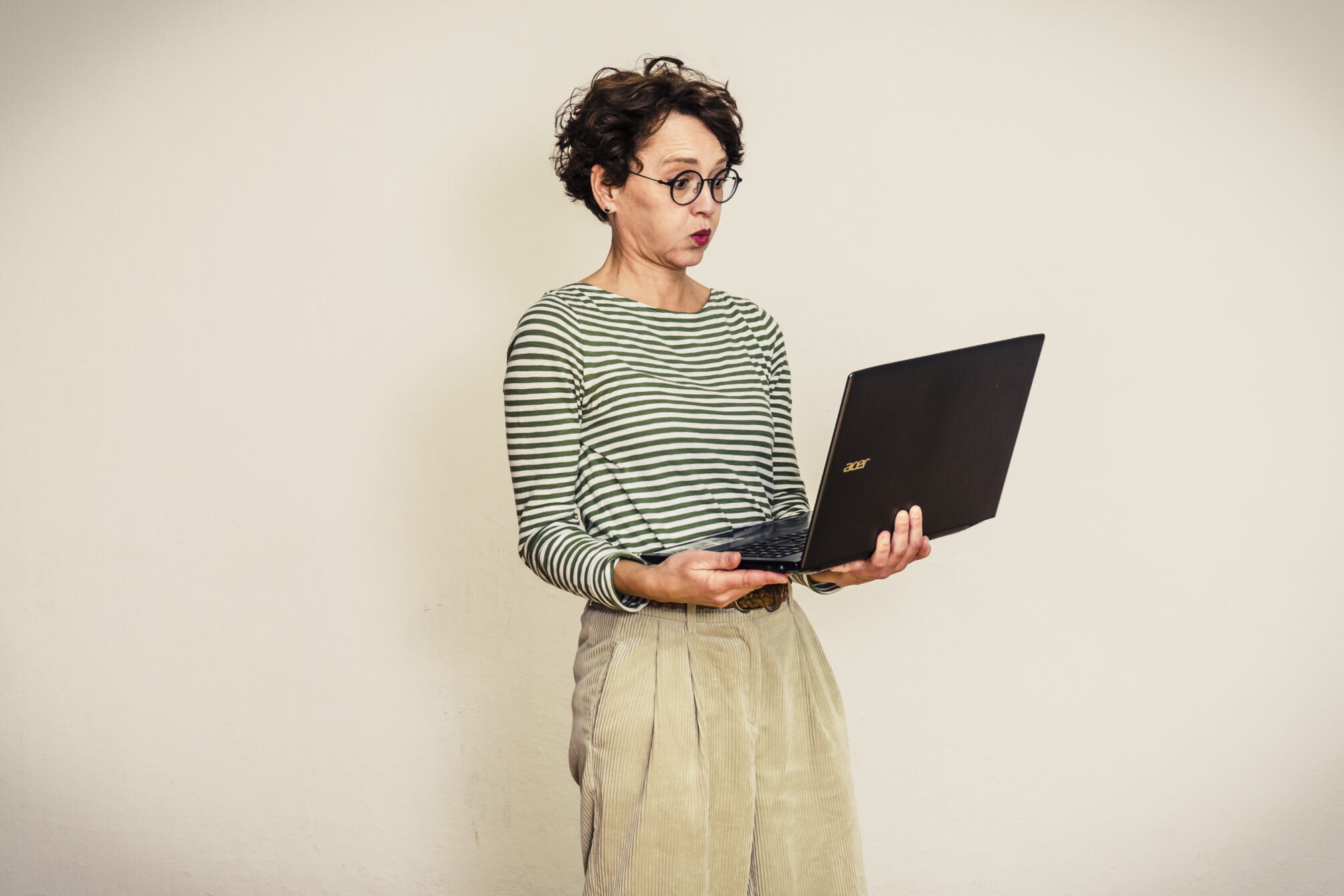 Frau blickt entgeistert auf den Laptop