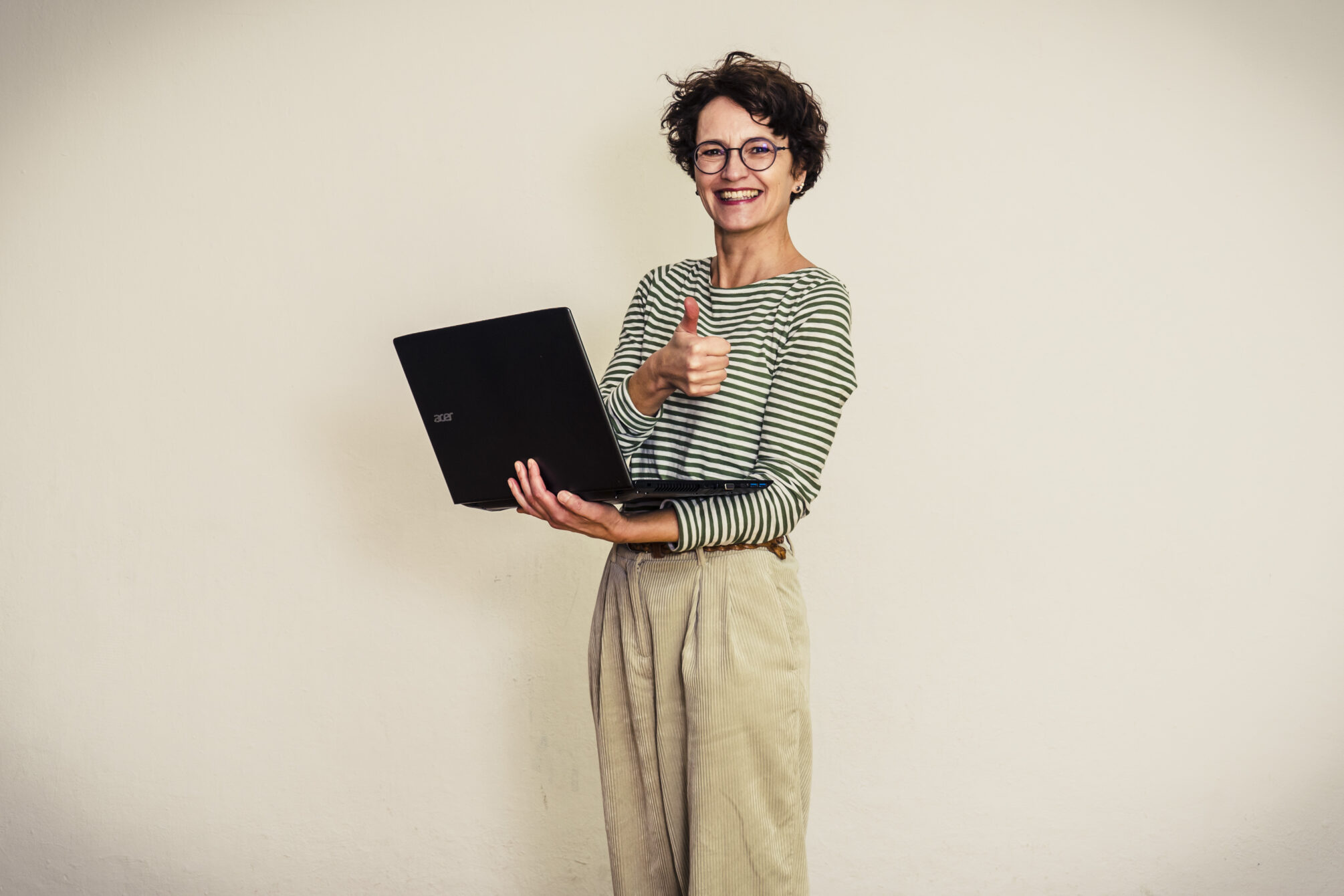 Frau mit Laptop und Daumen hoch