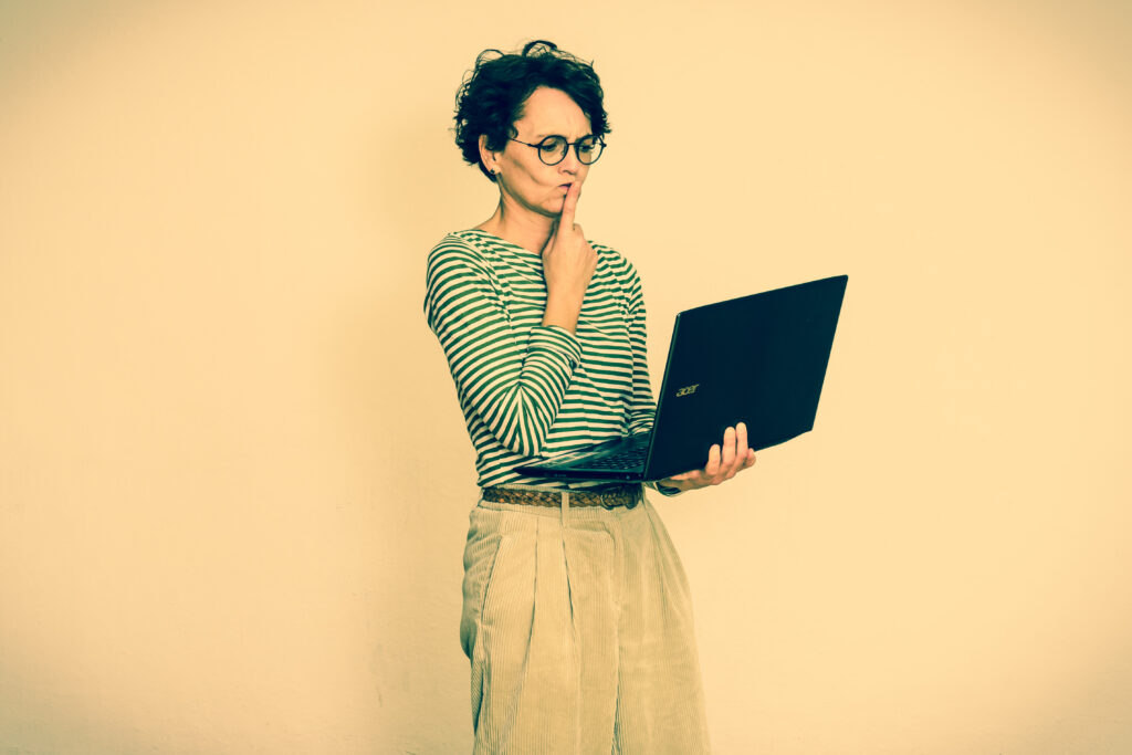 Frau blickt nachdenklich auf den Laptop