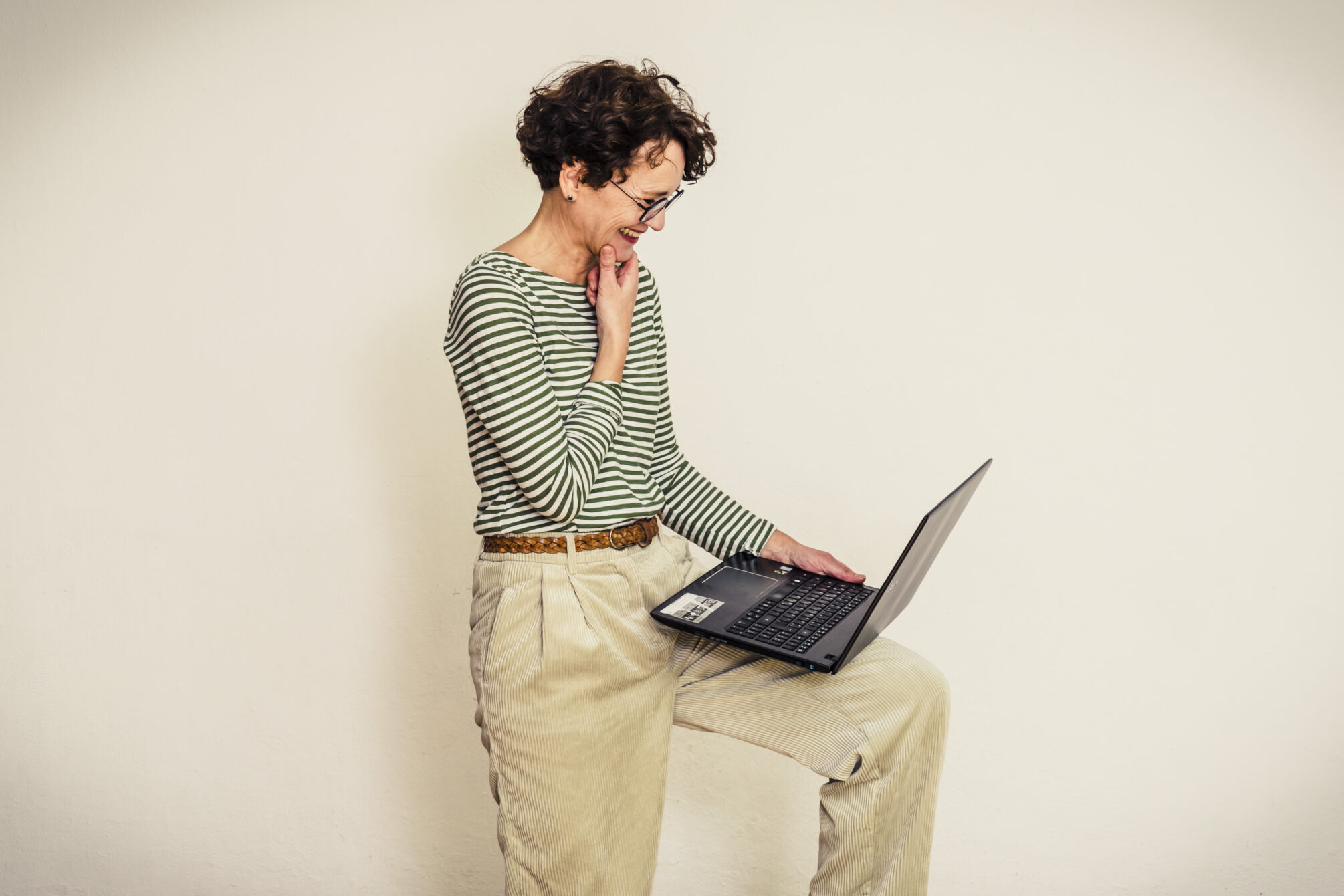 Keywords richtig platzieren: Frau blickt fröhlich auf den Laptop