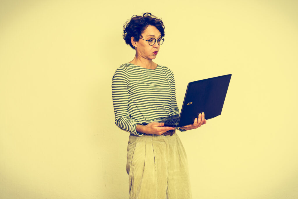 Eva Dragosits schaut entgeistert auf den Laptop